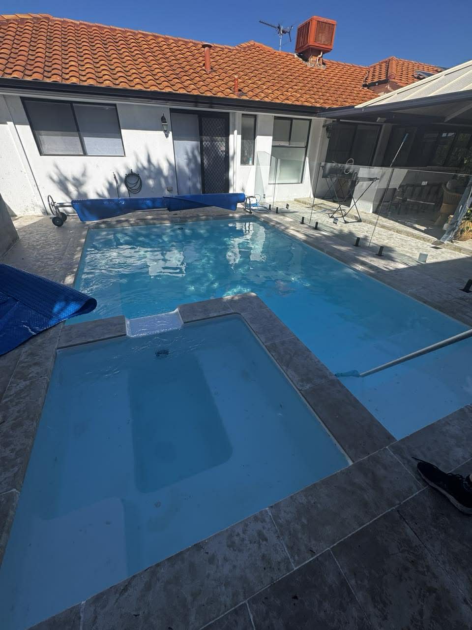 Pool test kit and water sample being checked beside a pool