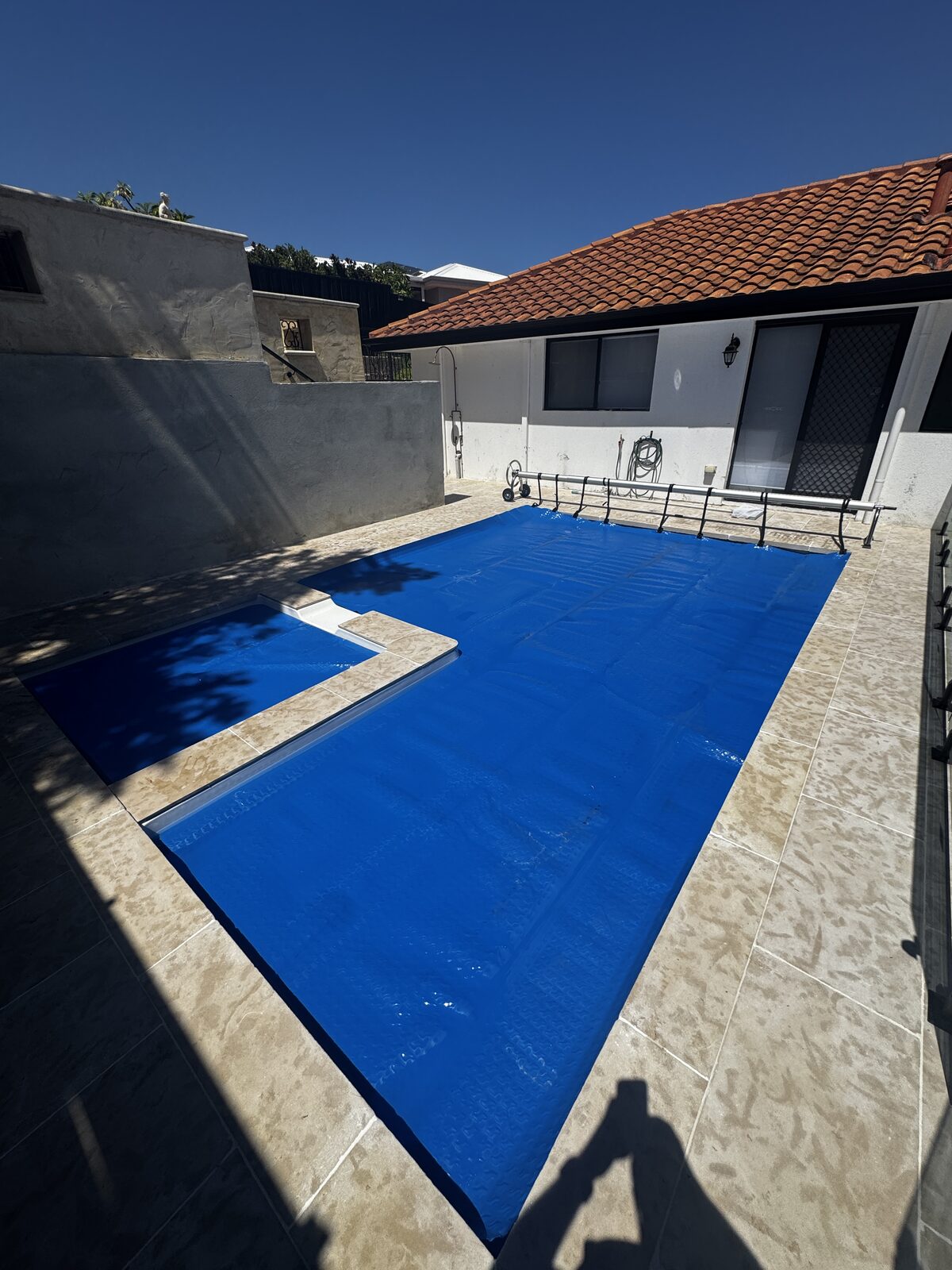 A covered swimming pool in autumn with fallen leaves nearby